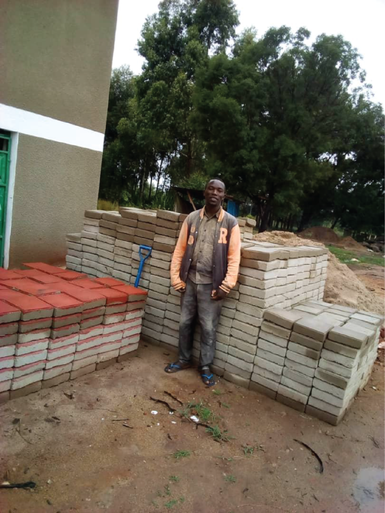 one of the workers with the blocks for the new courtyard at Touco.